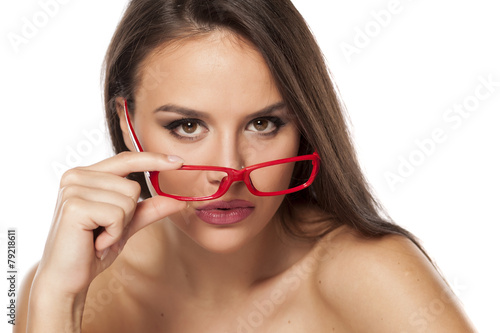 beautiful young woman looking over her glasses