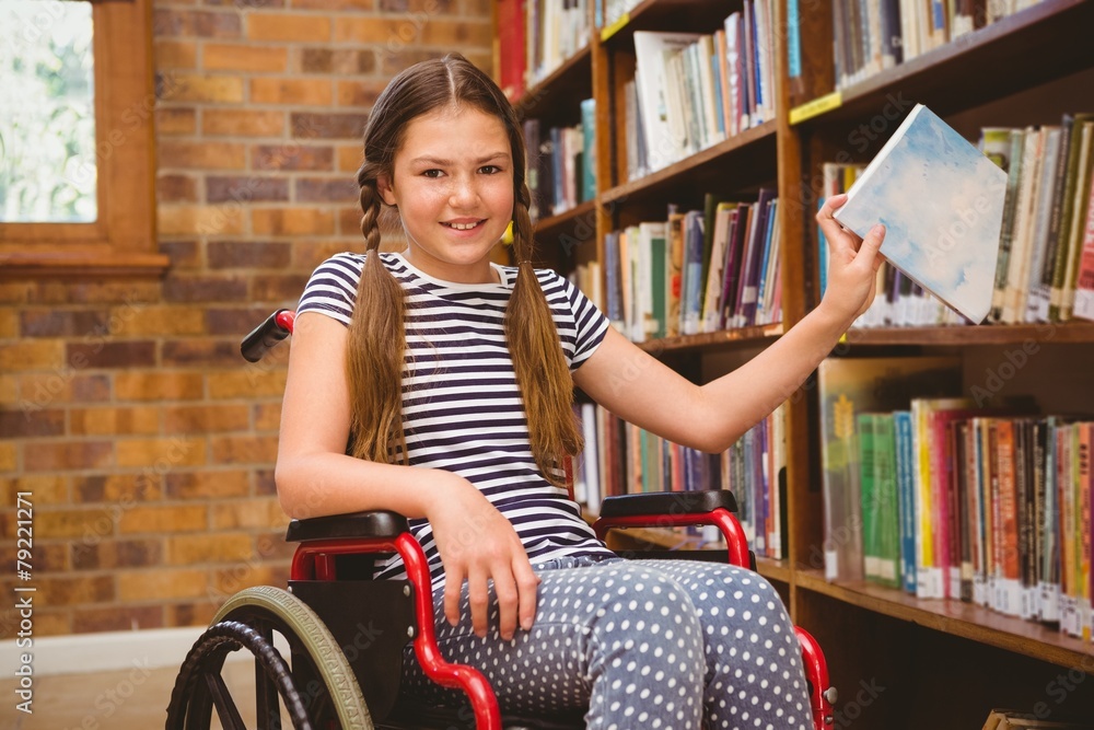 Girl in wheelchair selecting book in library Girl in wheelchair selecting book in library