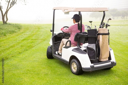 Golfer driving in his golf buggy