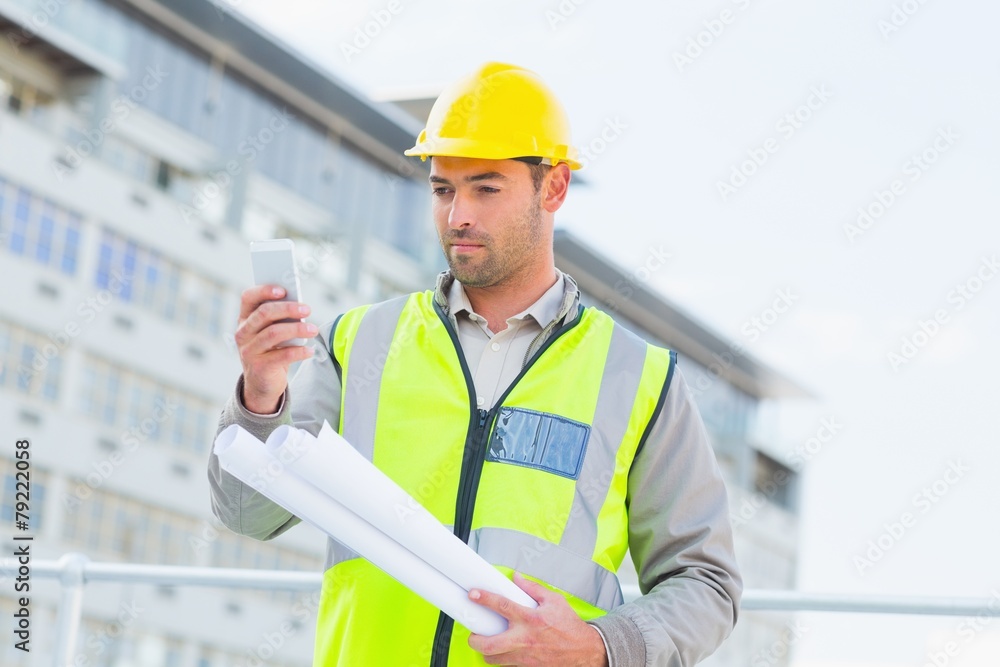 Architect using smartphone against building Architect using smartphone against building