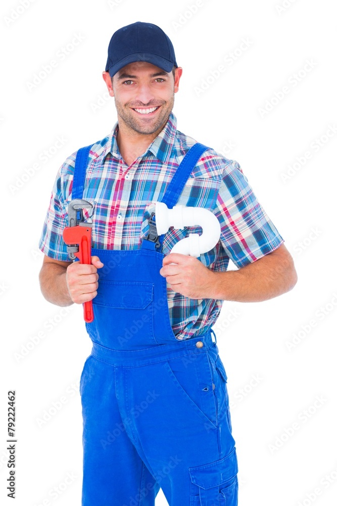 Happy male plumber holding monkey wrench and sink pipe Happy male plumber holding monkey wrench and sink pipe