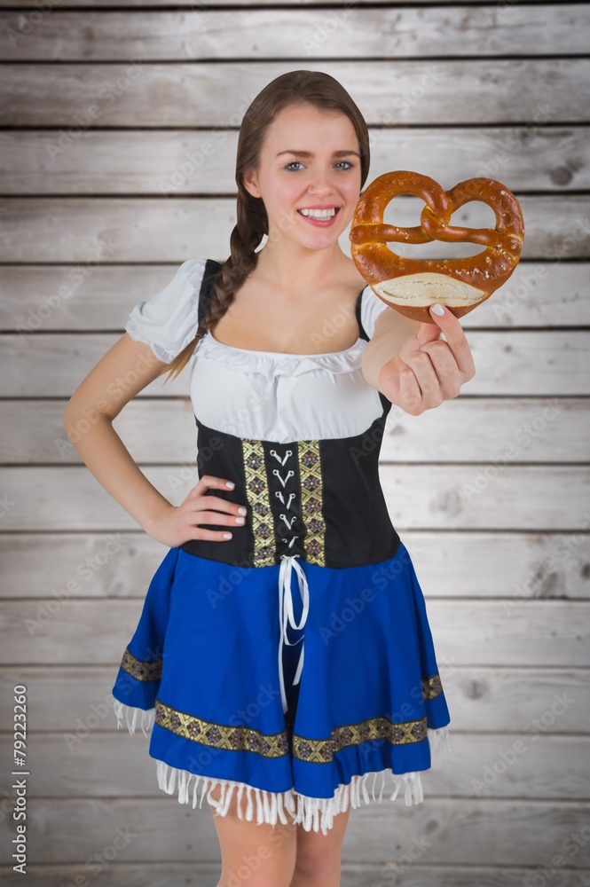 Composite image of pretty oktoberfest girl holding pretzel Composite image of pretty oktoberfest girl holding pretzel