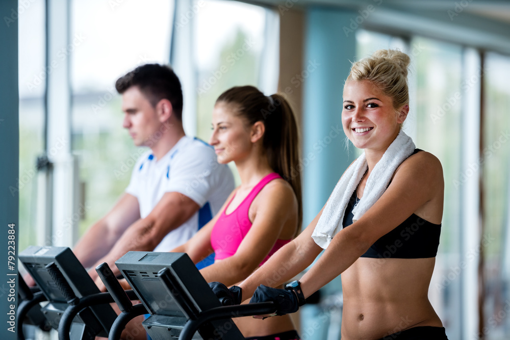 friends exercising on a treadmill at the bright modern gym friends exercising on a treadmill at the bright modern gym