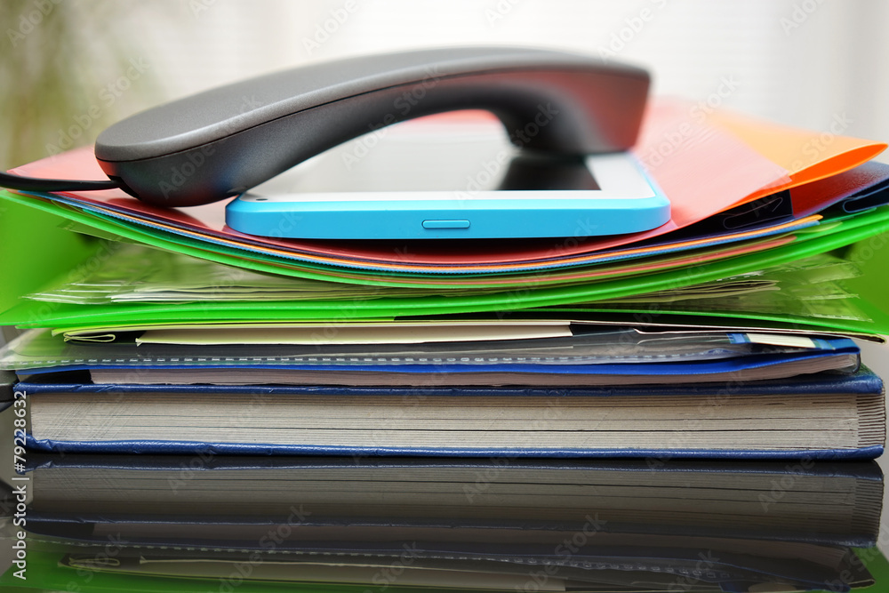 Handset and tablet computer on top of the files and folders. acc