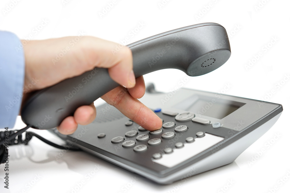 Businessman finger pressing a number button on the land line tel Businessman finger pressing a number button on the land line tel