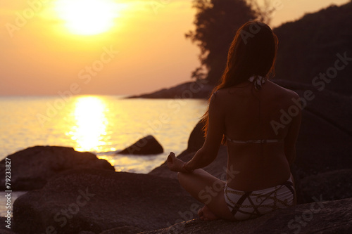 woman meditating on the sea sun beach