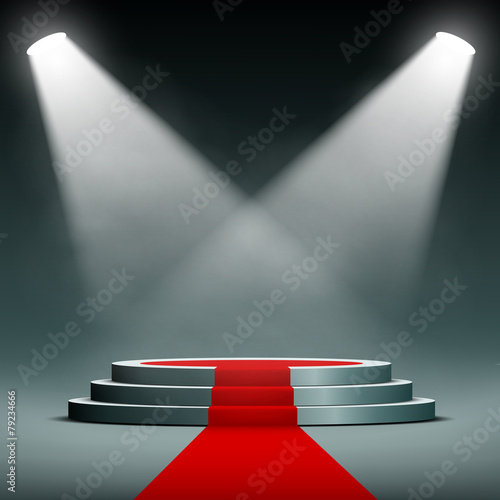 spotlights illuminate the pedestal with red carpet