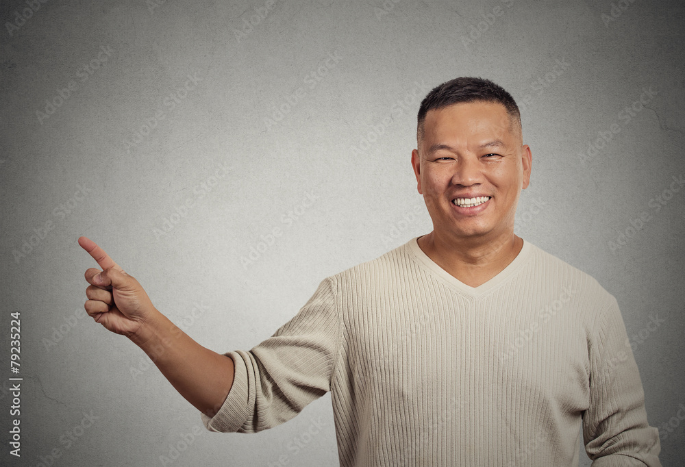 Handsome welcoming man pointing finger presenting copy space