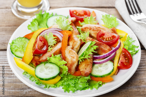 Salad with grilled chicken fillet tomatoes peppers and cucumber