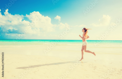 Young woman running on summer beach on coast of the ocean © pathdoc