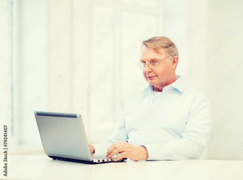 old man in eyeglasses working with laptop at home old man in eyeglasses working with laptop at home