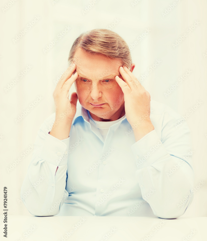 stressed old man holding head at home stressed old man holding head at home