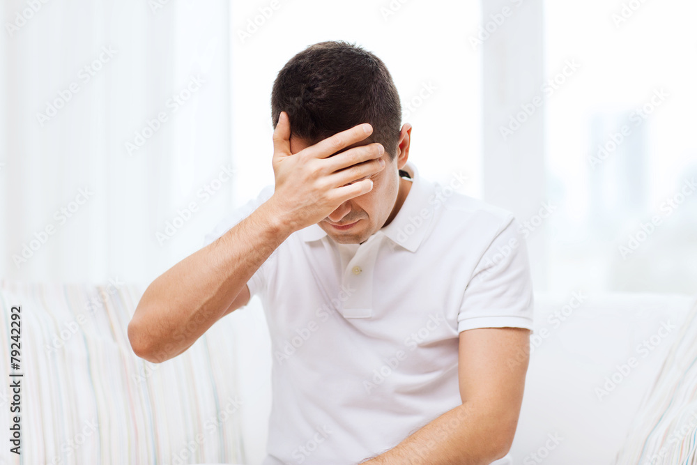 unhappy man suffering from head ache at home unhappy man suffering from head ache at home