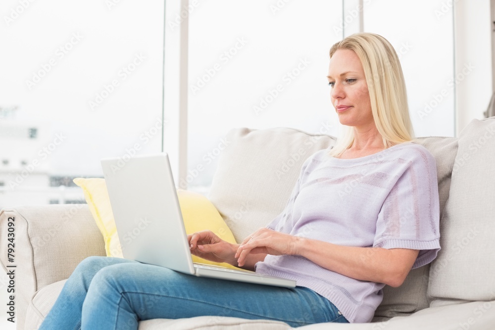 Woman using laptop on sofa Woman using laptop on sofa