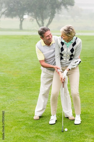 Golfing couple putting ball together