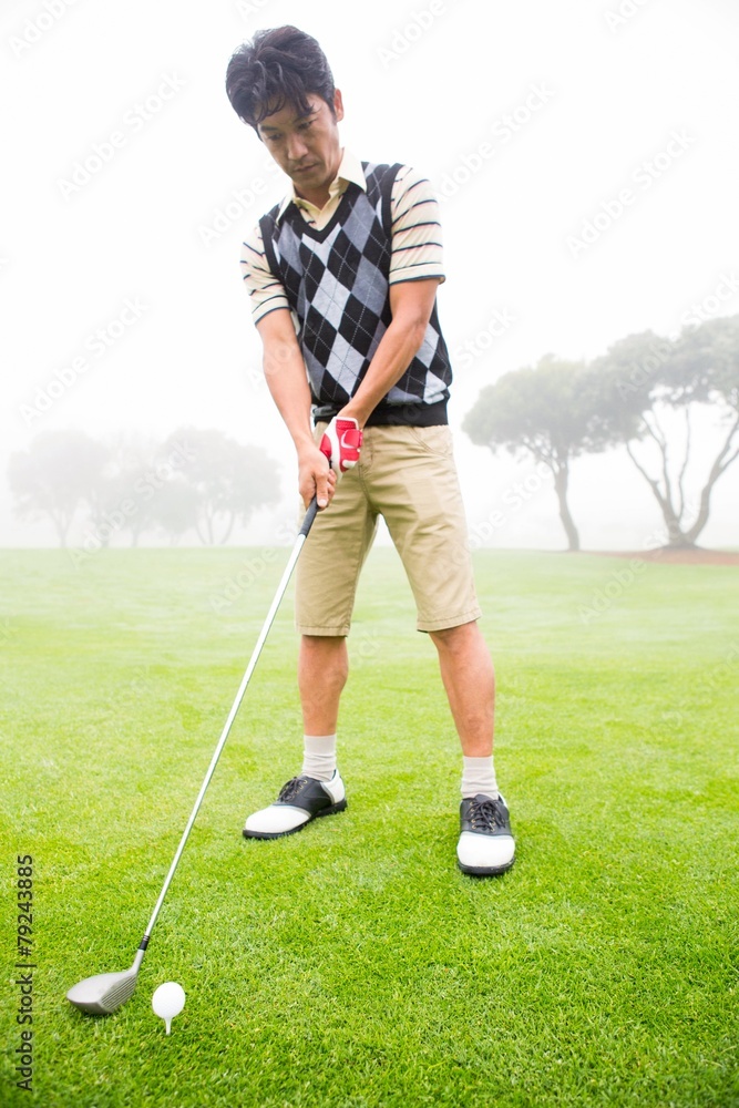 Fototapeta premium Concentrating golfer lining up his shot