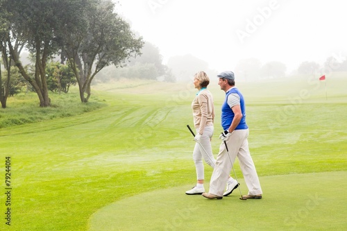 Golfing couple walking on the putting green