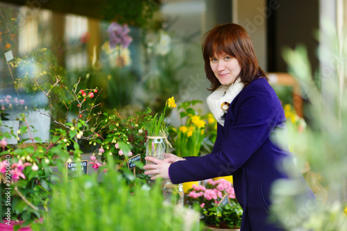 Beautiful woman selecting flowers at flower market