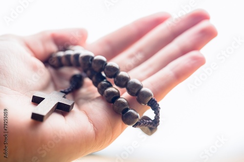 Hand holding wooden rosary beads