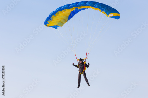 Skydiver on blue and yellow parachute closeup