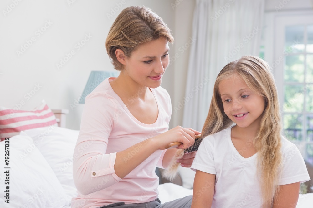 Mother brushing her daughters hair
