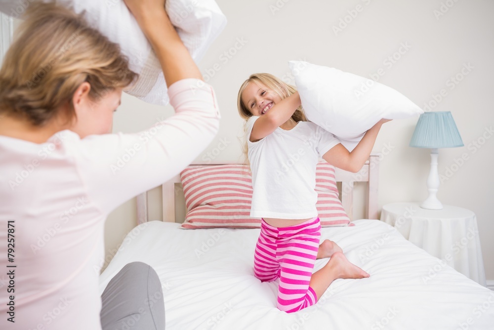 Mother and daughter having pillow fight Mother and daughter having pillow fight