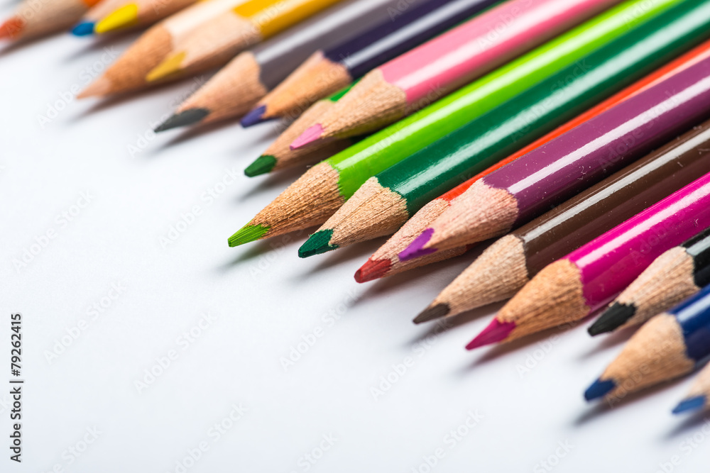 Several color pencils on a white paper sheet Several color pencils on a white paper sheet