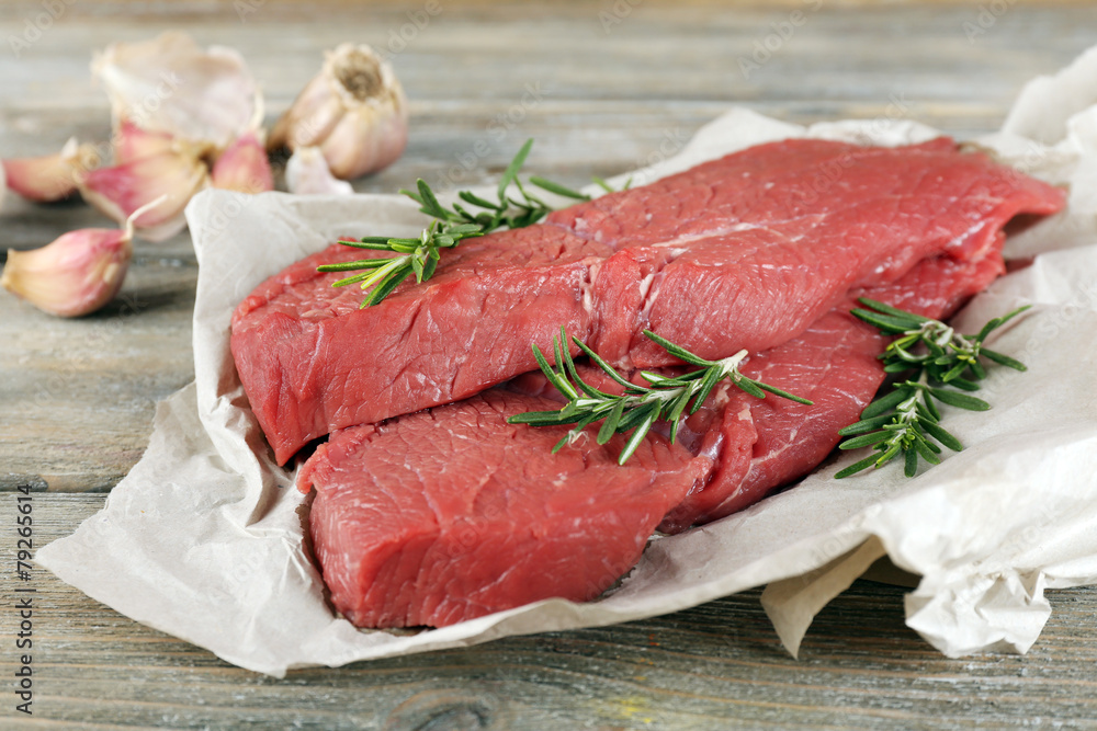 Raw beef steak with rosemary and garlic Raw beef steak with rosemary and garlic