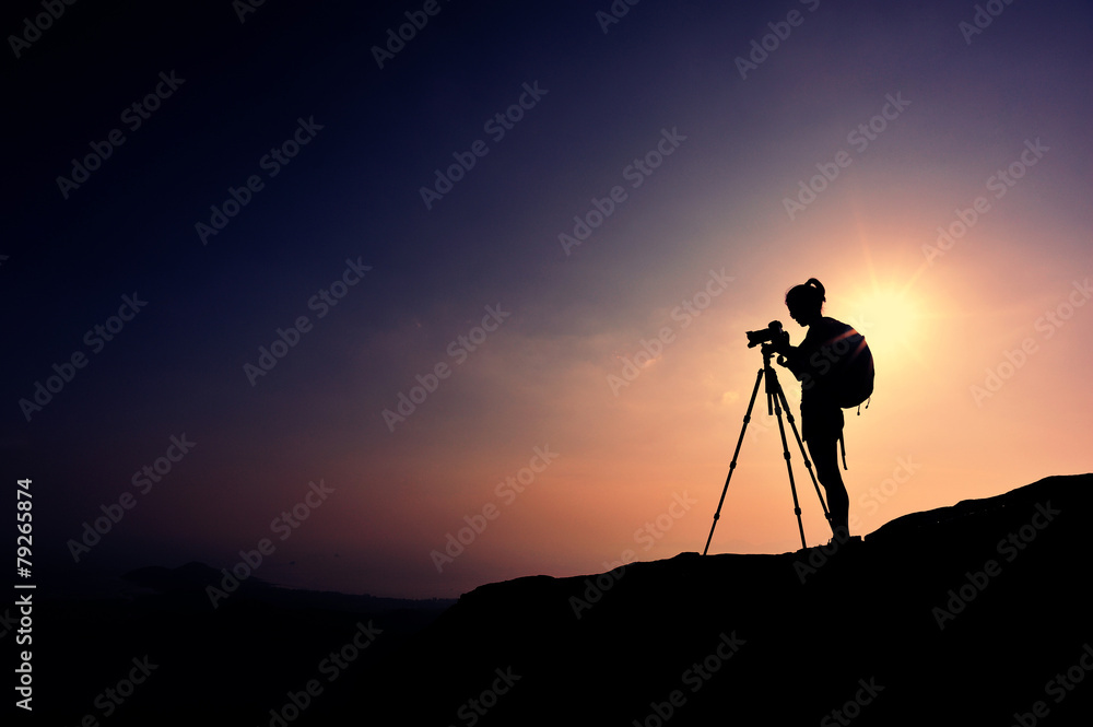 woman photographer taking photo on seaside mountain peak