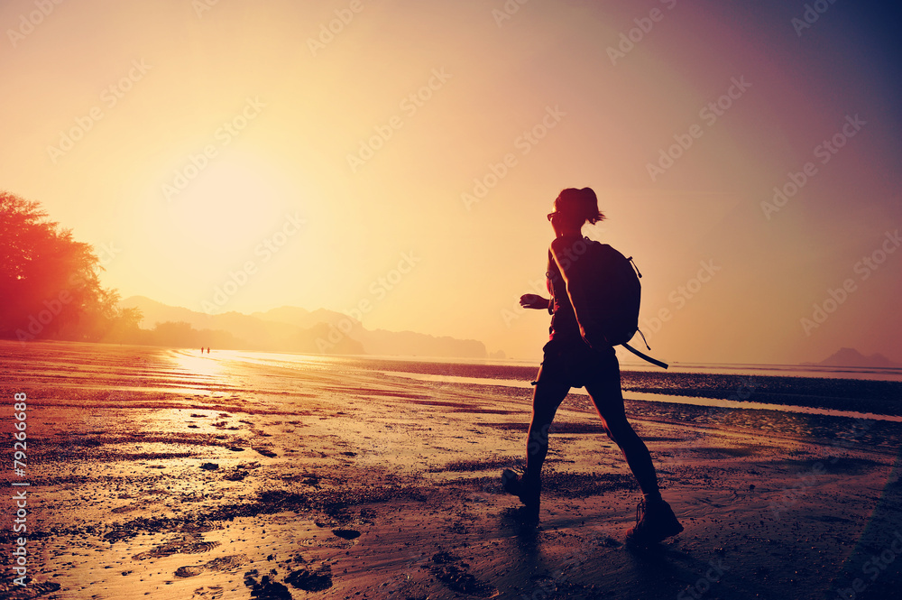hiking woman on sunrise beach