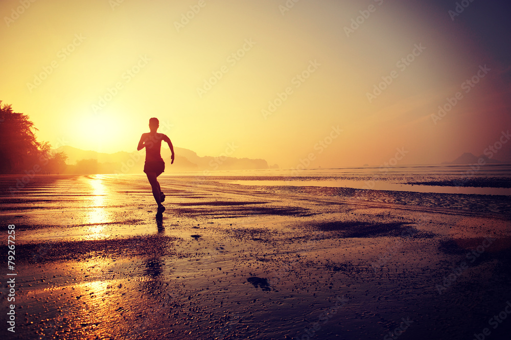 young woman running on sunrise beach 