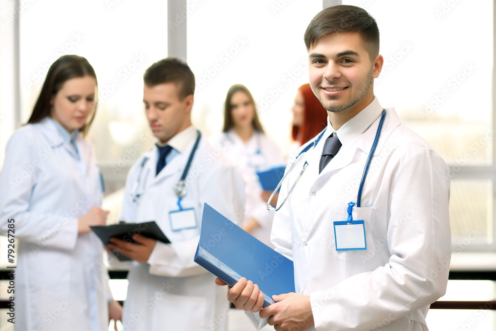 Attractive male doctor with team in conference room Attractive male doctor with team in conference room