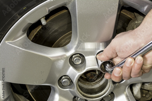 Using a wrench to tighten the nuts on a tire