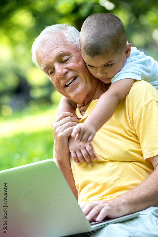 Obraz premium grandfather and child using laptop
