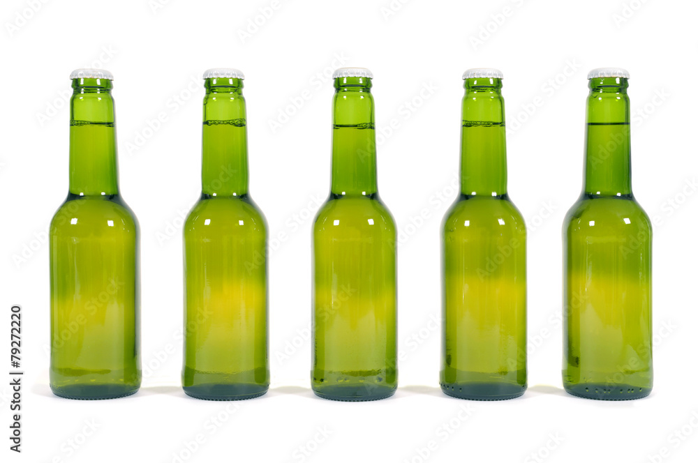 Row or line of green beer bottles isolated on white background photo Row or line of green beer bottles isolated on white background photo