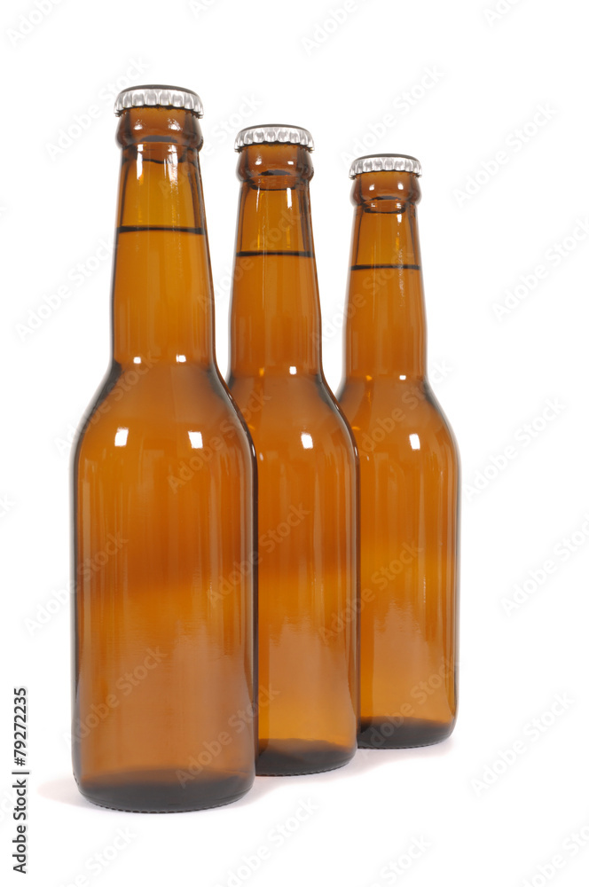 Row or line of three brown beer bottles isolated on white background photo