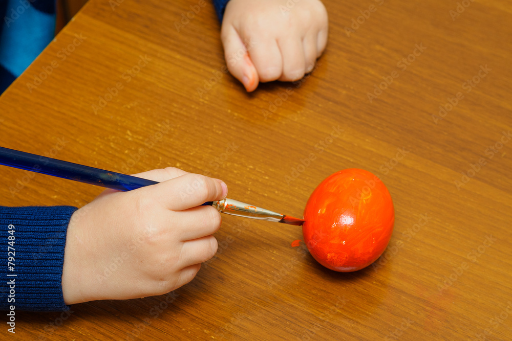 Kid painting red easter egg Kid painting red easter egg