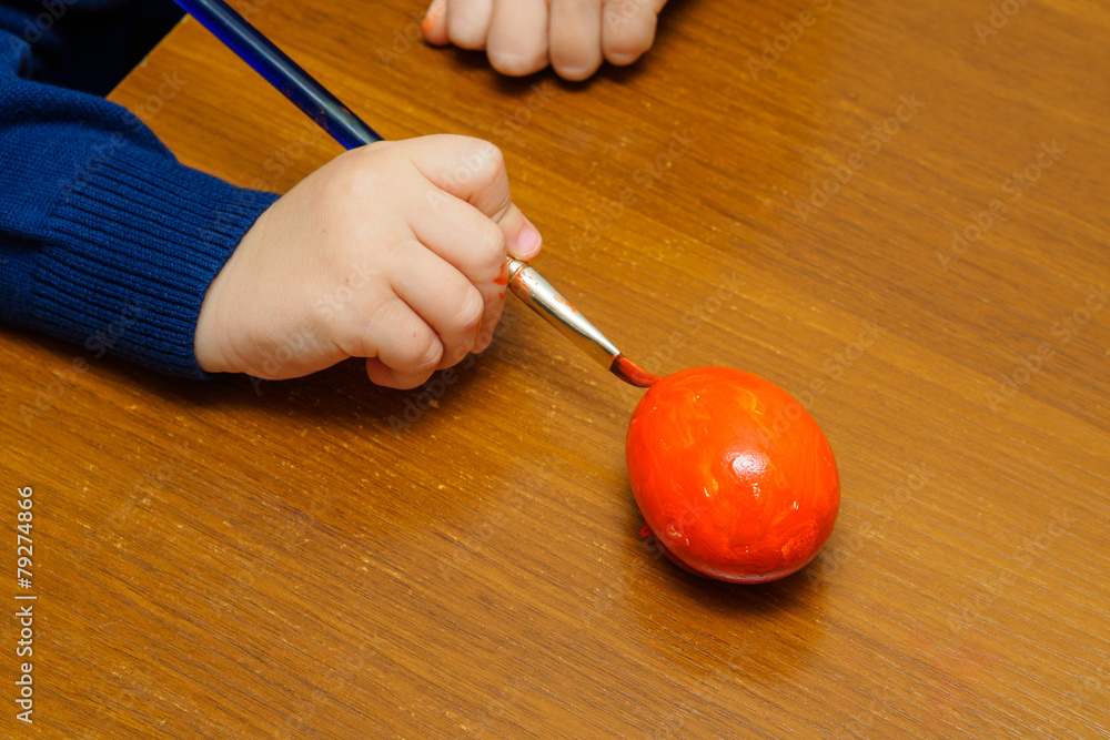 Kid painting red easter egg Kid painting red easter egg