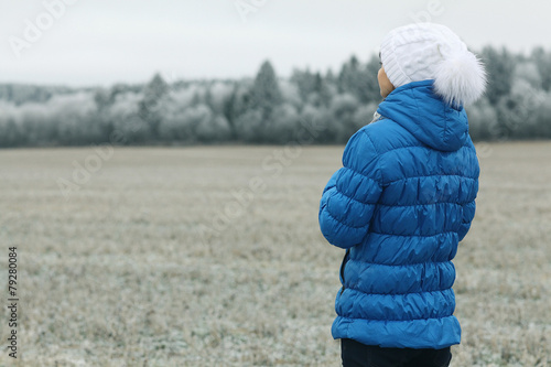 girl in a blue down jacket winter view from the back photo