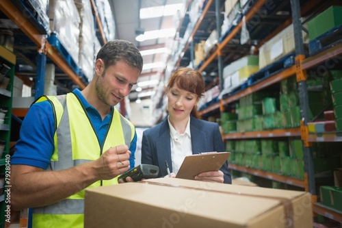 Worker and manager scanning package in warehouse