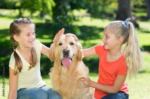 Sister petting their dog in the park