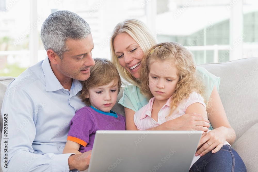Parents using laptop with children
