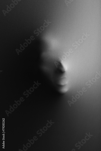 Human face pressing through fabric as horror background