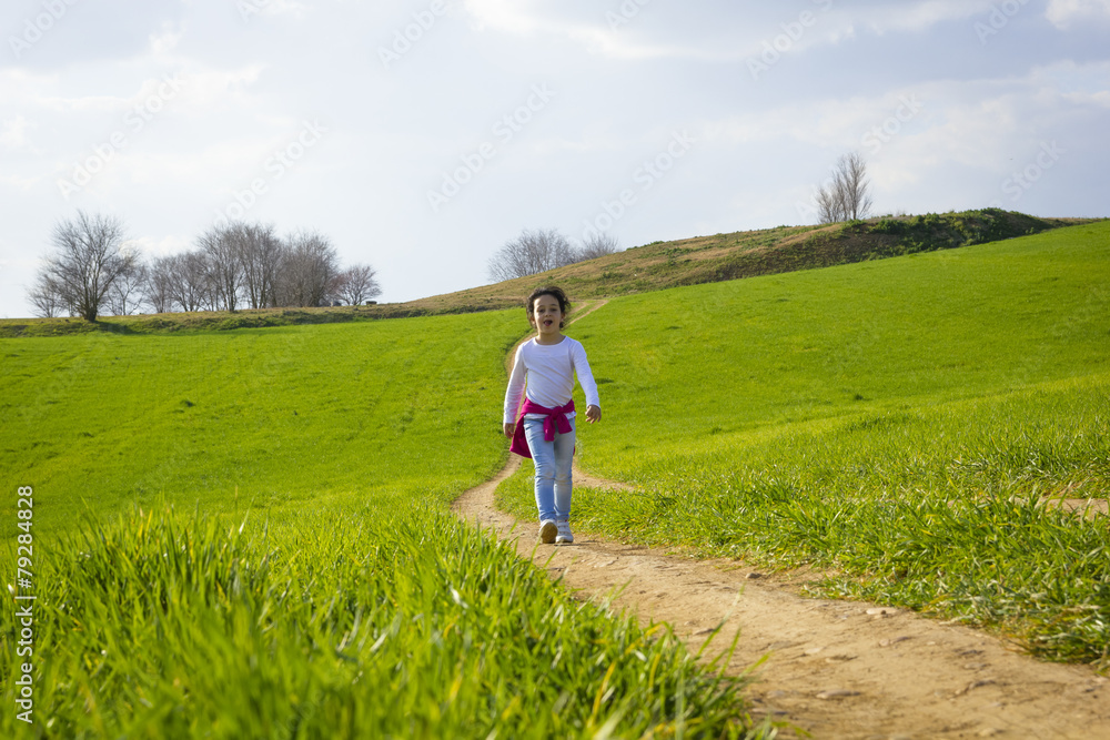 Niña corriendo y caminando feliz por el camino en el campo Niña corriendo y caminando feliz por el camino en el campo