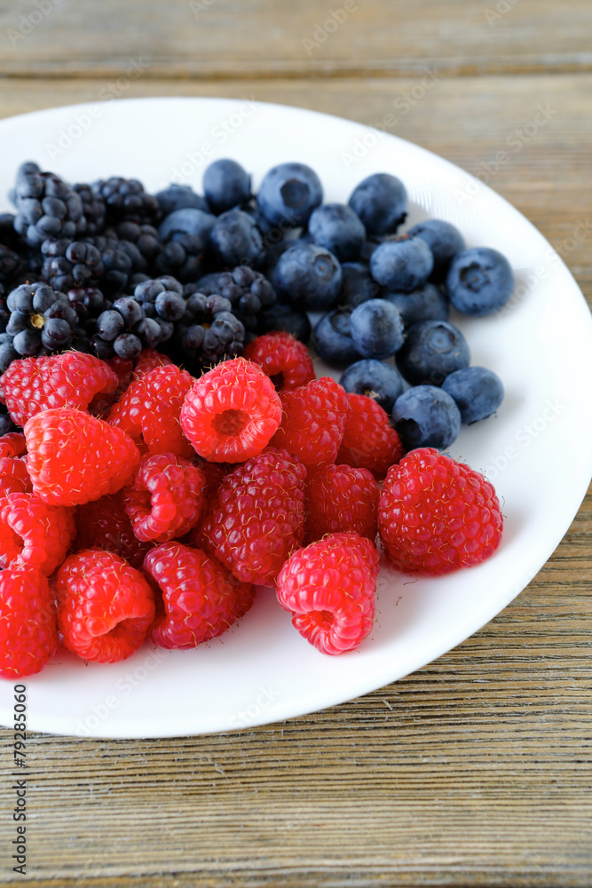 Raspberries and blackberries on a plate Raspberries and blackberries on a plate