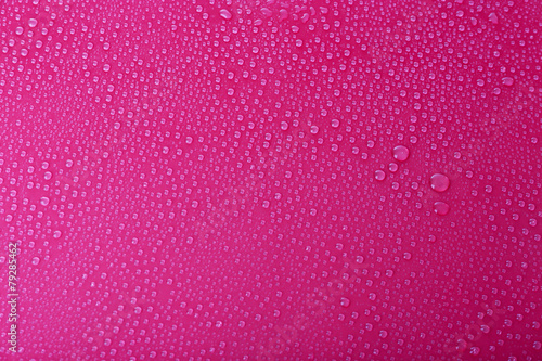 Water drops on glass on pink background