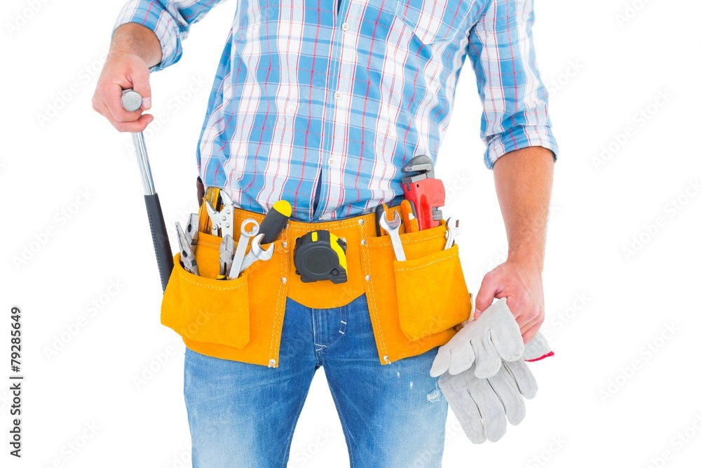 Midsection of handyman holding hammer and gloves Midsection of handyman holding hammer and gloves