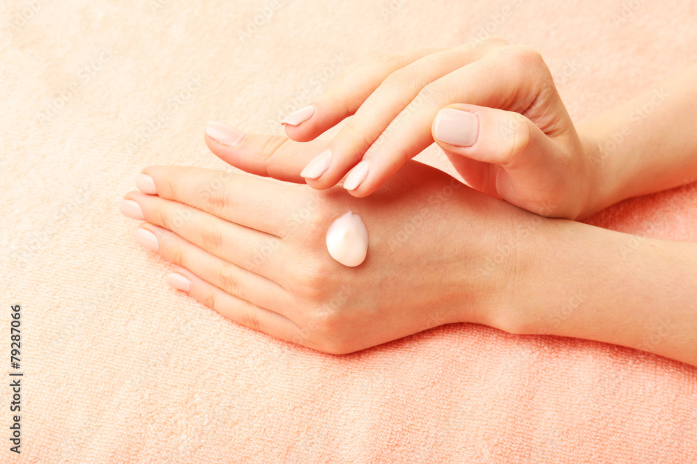 Woman caring hands with cream on fabric background Woman caring hands with cream on fabric background