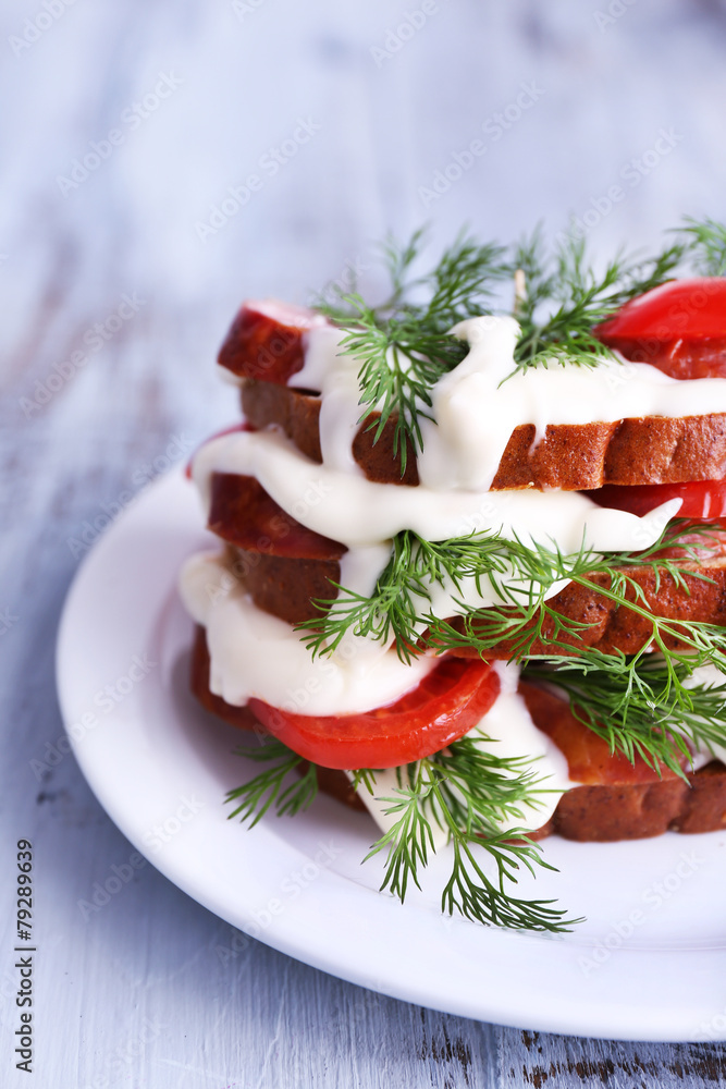 Sandwich with sausage, tomato and mayonnaise on plate, closeup Sandwich with sausage, tomato and mayonnaise on plate, closeup