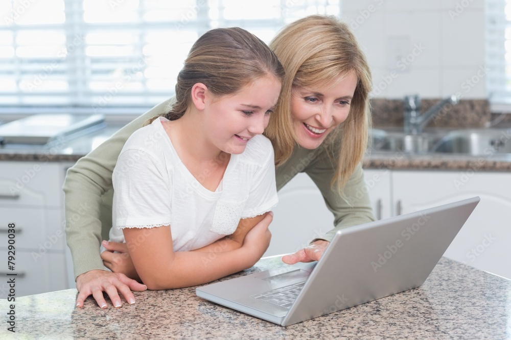 Happy mother and daughter using laptop together Happy mother and daughter using laptop together